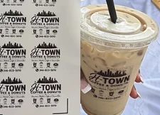 Sample logo stickers on a sheet and on an iced coffee cup; illustrative example